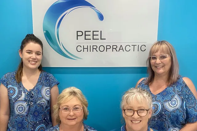 Four of our chiropractic assistants in front of the Peel Chiropractic sign