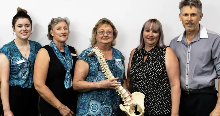 Dr Brett Watson with four of our chiropractic assistants, one holding a spine model