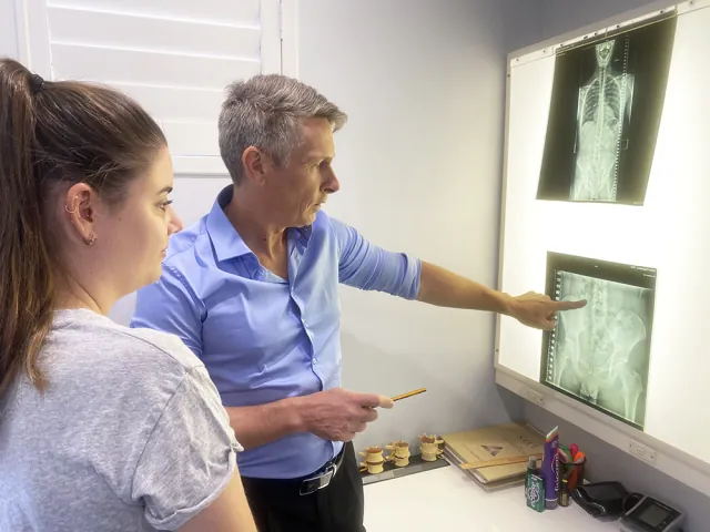 Dr Brett Watson goes over a patient's x-rays on the lightbox
